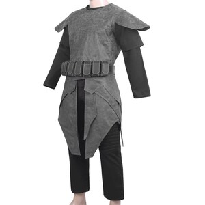 Pu&ograve; includere: Un costume grigio con un design a strati, caratterizzato da un gilet strutturato, spalline e una cintura con tasche. Il costume include una camicia nera a maniche lunghe e pantaloni. L'outfit &egrave; progettato per cosplay o eventi a tema.
