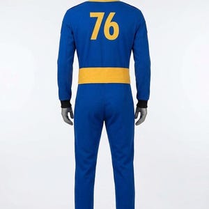 Full back view of the Fallout cosplay Vault Dweller jumpsuit, featuring a prominently displayed large golden-yellow '76' vault number on the blue back panel, along with the rear waist belt detail