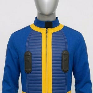 Close-up shot of the Fallout cosplay vault suit’s front panel, detailing the horizontal ribbed yellow padding, the metallic central zipper, and the two black vertical utility chest pouches