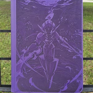 Peut inclure: Un classeur rectangulaire violet présentant un motif en relief d'une silhouette blindée stylisée aux traits anguleux et aux effets d'énergie fluides. Le mot ZOPLY est gravé dans le coin inférieur droit de la surface texturée de la couverture.