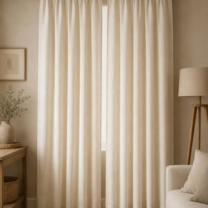 Puede incluir: Un par de cortinas de color blanco roto que llegan hasta el suelo, colgadas de una barra de color marrón oscuro. Las cortinas presentan un diseño sencillo y recto con pliegues verticales que se extienden desde la barra hasta el suelo.