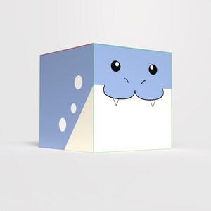 Puede incluir: Caja cúbica azul y blanca con un diseño de cara de tiburón de dibujos animados. La cara del tiburón tiene ojos negros, un hocico azul y pequeños dientes blancos. Círculos blancos y un triángulo amarillo claro en el lateral.