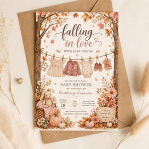 May include: A baby shower invitation card featuring autumn-themed illustrations of trees, pumpkins, flowers, and a bunny in a basket. A clothesline displays baby clothing. The text reads: falling in love with baby owens, baby shower, Brittany Lawson.