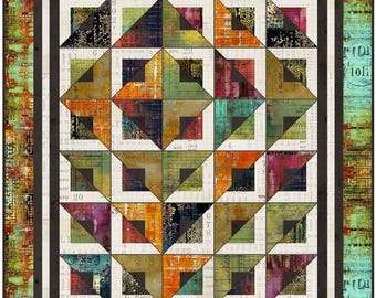 May include: A rectangular quilt featuring a grid of square blocks with triangular patterns in shades of orange, green, teal, and black. The fabric displays printed text and numbers on a cream background, framed by a dark border and a textured outer edge.