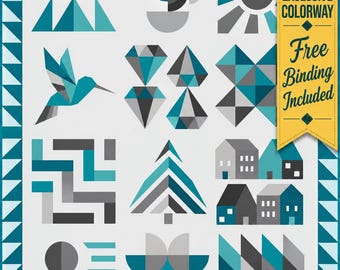 May include: A quilt featuring a grid of geometric patterns in teal, gray, and white. Designs include a hummingbird, diamonds, houses, trees, and abstract shapes. A yellow banner on the right reads SHOP EXCLUSIVE COLORWAY Free Binding Included.