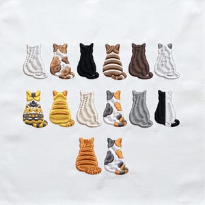 Könnte beinhalten: Quadratischer weißer Stoff mit gestickten Katzenmotiven. Die Katzen sind von hinten dargestellt, mit verschiedenen Mustern und Farben, darunter Schwarz, Braun, Orange und Grau. Die Stickerei ist detailliert und zeigt das Fell und die Haltung der Katzen.