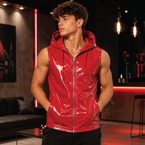 Può includere: Un gilet rosso senza maniche con cappuccio realizzato in un materiale lucido simile alla vernice. Il capo presenta una chiusura frontale con zip color argento, un cappuccio con cordini rossi abbinati e due tasche anteriori.