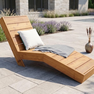 Può includere: Una chaise longue in legno con un cuscino bianco e una coperta grigia. La sedia a sdraio è realizzata in legno marrone chiaro ed è angolata per un comodo relax. È presente anche un vaso decorativo con piante essiccate.