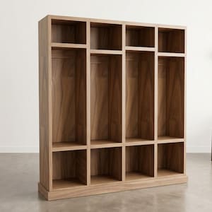 Op de afbeelding: Een hoge houten opbergkast met een lichtbruine afwerking. Het heeft een reeks open compartimenten en planken, die voldoende opbergruimte bieden. De kast is ontworpen met een combinatie van kubussen en verticale secties, geschikt voor diverse opslagbehoeften.