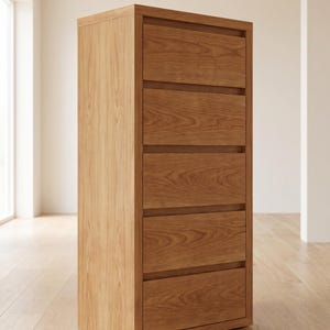 Può includere: Una cassettiera alta in legno con sei cassetti. I lati sono in legno chiaro, mentre i frontali dei cassetti sono in legno più scuro. I cassetti sono orizzontali e hanno un design semplice e moderno. La cassettiera è appoggiata su un pavimento in legno chiaro.