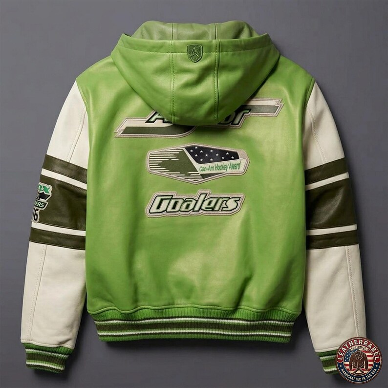 May include: Green leather jacket with a hood and white sleeves. The back features the text "Coolers" and "Can-Am Hockey Award". The jacket has a green and white striped trim at the cuffs and waist. A shield logo is on the hood.