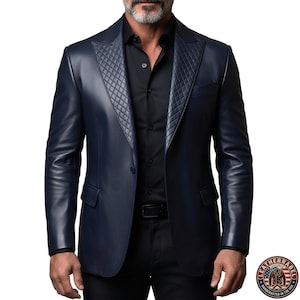 Puede incluir: Una blazer de cuero azul marino con solapa acolchada. La blazer tiene cierre de dos botones y un corte cl&aacute;sico. La imagen tambi&eacute;n muestra una camisa y cintur&oacute;n negros. El logotipo de Leather Label es visible en la esquina inferior derecha.