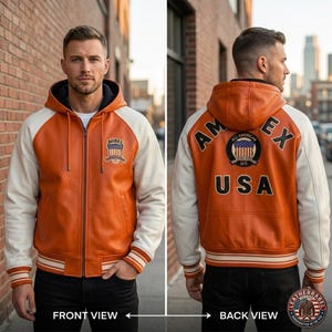 K&ouml;nnte beinhalten: Orange-cremefarbene Lederjacke mit Kapuze. Die Jacke hat einen Frontrei&szlig;verschluss, gerippte B&uuml;ndchen und einen gestreiften Saum. Auf der Vorderseite befindet sich ein Aufn&auml;her mit Text, auf der R&uuml;ckseite "AM EX USA" und ein rundes Emblem.