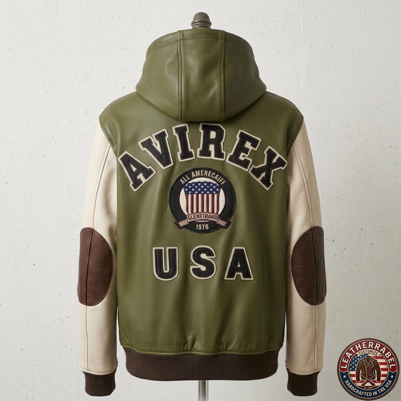 May include: An olive green hooded jacket with cream-colored sleeves and dark brown elbow patches. The back features the text AVIREX in black, a circular patch with a US flag design and the text ALL AMERECAIFF GLENETRANS 1976, and the text USA below.