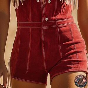 Puede incluir: Un romper de ante rojo oscuro con dise&ntilde;o de cintura alta, costuras blancas en contraste, cierre de botones frontal y detalles de flecos largos en los laterales. Un logotipo circular con una bandera y texto es visible en la esquina.