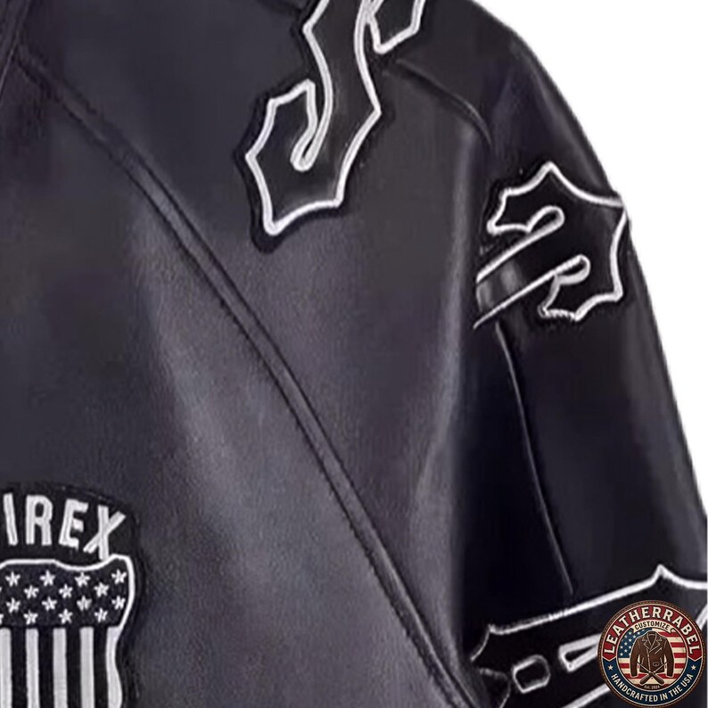 May include: Black leather jacket with white embroidered patches. The jacket features the word "IREX" on a patch with a star and stripe design. Additional patches with stylized lettering are also visible.