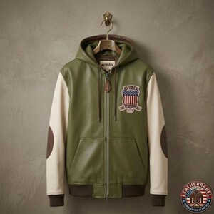 May include: An olive green leather hoodie jacket with cream-colored sleeves and dark brown elbow patches. The jacket features a front zipper, a hood with drawstrings, and a patch on the chest displaying the text AVIREX with a US flag shield design.