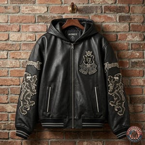 May include: A black leather hooded jacket featuring a full-length front zipper, ribbed cuffs and hem with white stripes, and embroidered patches on the chest and sleeves. The chest patch displays a crest with the text Avirex New York.