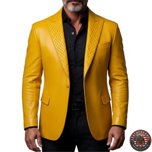 Puede incluir: Blazer de cuero amarillo mostaza con solapas acolchadas y cierre de dos botones. El blazer tiene un corte entallado y presenta un bolsillo en el pecho y bolsillos laterales. El modelo lleva camisa y pantal&oacute;n negros. Hecho a mano en EE. UU.