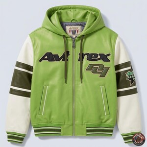 May include: A green leather jacket with a hood, white sleeves, and olive green accents. The jacket features the brand name "AVIREX" in black and olive green lettering across the chest. The sleeves have olive green stripes and a patch that says "All Stars".