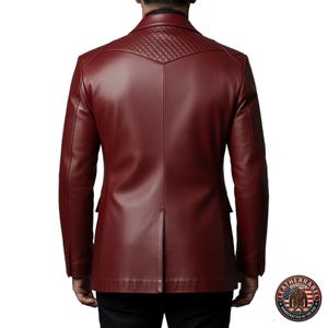 Puede incluir: Blazer de cuero burdeos con canes&uacute; acolchado en los hombros. La vista trasera muestra un corte entallado con cierre de dos botones y solapas con muescas. El blazer tiene un dise&ntilde;o cl&aacute;sico con un toque moderno.