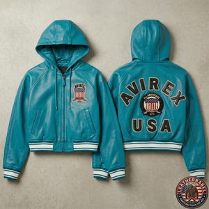 K&ouml;nnte beinhalten: Eine t&uuml;rkisfarbene Lederjacke mit Kapuze und Rei&szlig;verschluss, die auf der Brust einen kleinen Aufn&auml;her mit einer amerikanischen Flagge und dem Text AVIREX tr&auml;gt. Der R&uuml;cken zeigt den Schriftzug AVIREX USA und ein rundes Abzeichen.