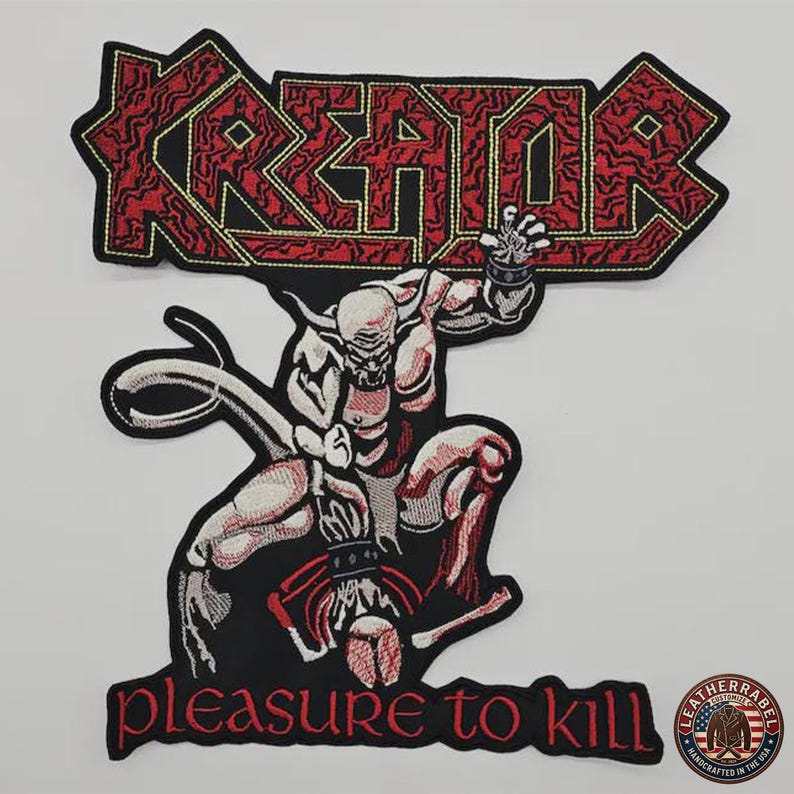 K&ouml;nnte beinhalten: Gestickter Aufn&auml;her mit dem Wort "KREATOR" in Rot, umrandet in Schwarz und Gelb. Darunter eine muskul&ouml;se D&auml;monenfigur in Rot, Wei&szlig; und Schwarz, mit dem Text "pleasure to kill" unten. Ein kreisf&ouml;rmiger Aufn&auml;her mit Text befindet sich unten rechts.