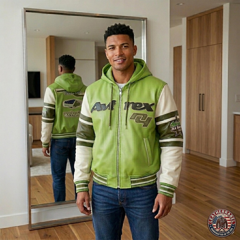 May include: A green and cream-colored zip-up jacket with the text "Avirex" on the chest. The jacket has a hood and ribbed cuffs and hem. The sleeves are cream-colored with green and brown stripes.