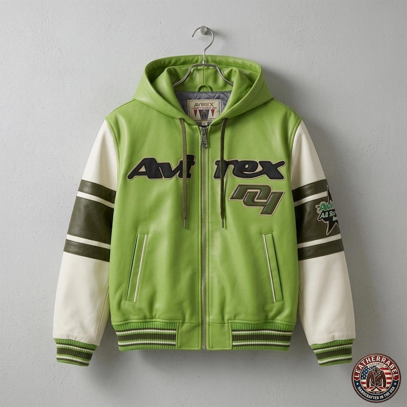 May include: A green leather jacket with a hood, white sleeves, and olive green stripes. The jacket features the text "Avirex" in black and a patch that says "All Stars". The jacket is hanging on a metal hanger.