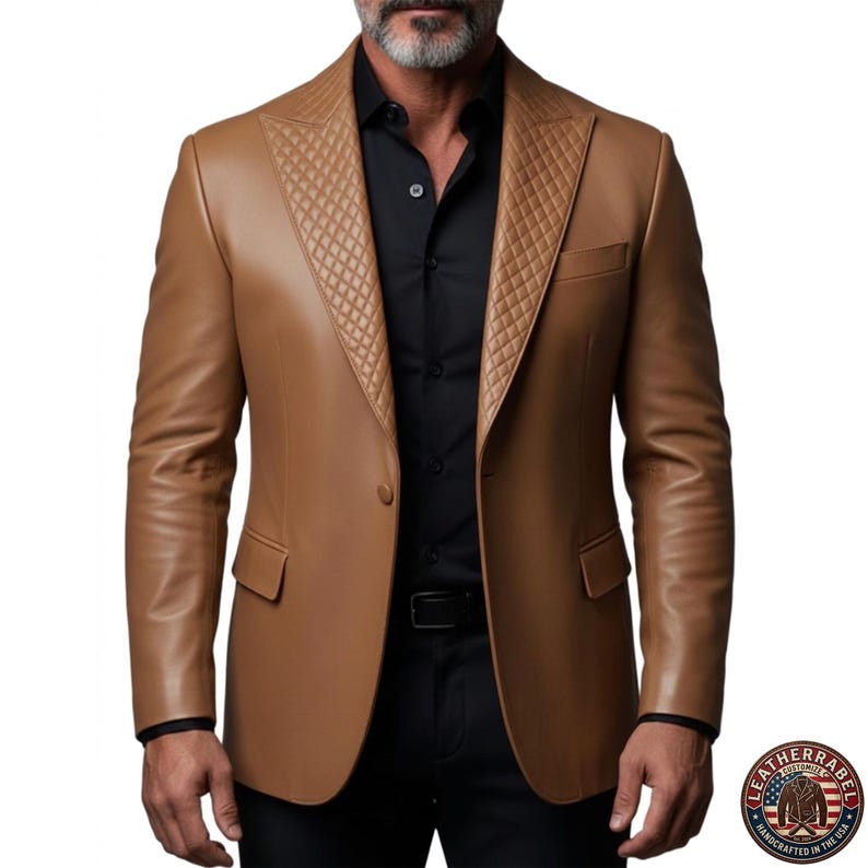 Puede incluir: Una blazer de cuero marr&oacute;n claro con un dise&ntilde;o acolchado en las solapas. La blazer tiene cierre de dos botones, solapa con muescas y dos bolsillos delanteros. El modelo lleva una camisa negra y pantalones negros. La blazer es de LeatherRabel, hecha a mano en EE. UU.