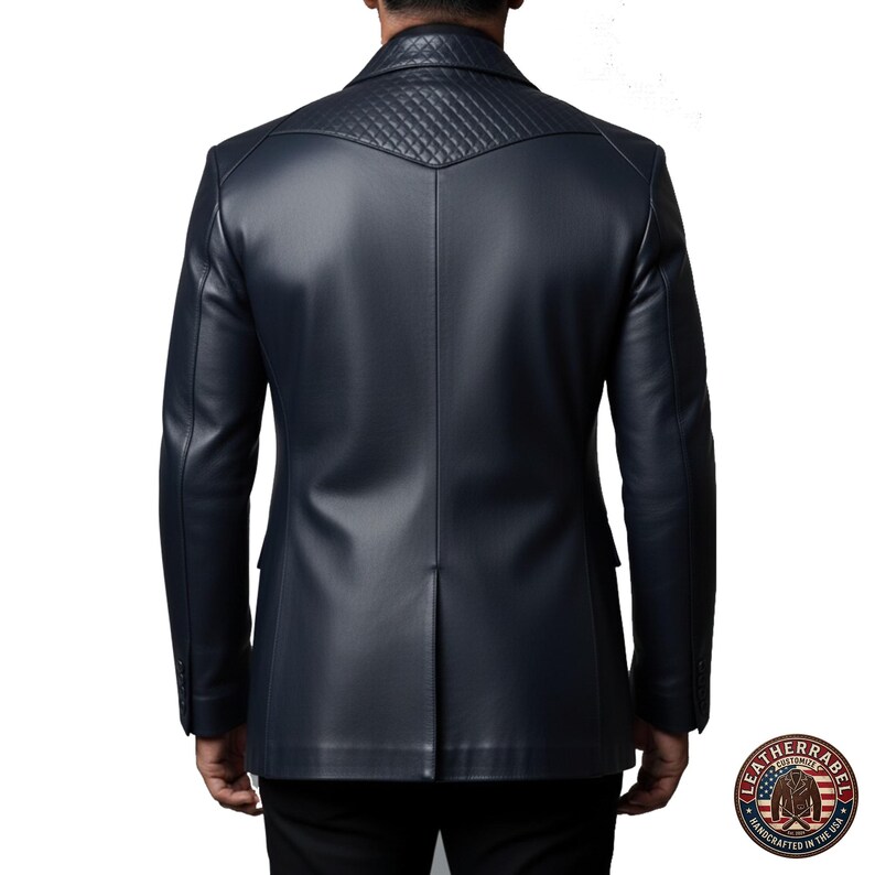 Puede incluir: Una blazer de cuero azul marino con canes&uacute; acolchado en los hombros. La blazer tiene cierre de dos botones y solapa con muescas. La parte trasera de la blazer tiene una abertura central. El logotipo de Leatherrabel es visible en la esquina inferior derecha.