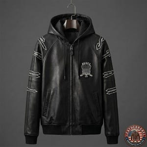 May include: Black leather hooded jacket with white embroidered accents and a front zipper. The jacket features the "AVIREX" logo on the chest and is hanging on a hanger. The jacket has a ribbed hem and cuffs.
