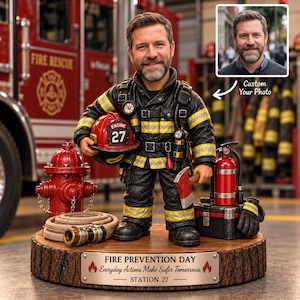 Könnte beinhalten: Eine personalisierte Feuerwehrfigur auf einem Holzsockel mit einer Plakette mit der Aufschrift FIRE PREVENTION DAY Everyday Actions Make Safer Tomorrows STATION 27. Die Figur trägt schwarze Schutzkleidung mit gelben Streifen, einen roten Helm mit der Aufschrift 27 und eine Axt.
