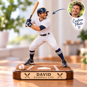 Könnte beinhalten: Eine personalisierte Baseballspieler-Figur auf einem Erdsockel mit Home Plate und Baseball. Die Figur trägt eine gestreifte Uniform, einen marineblauen Helm und Socken und hält einen Holzschläger. Eine Plakette am Sockel zeigt DAVID BASEBALL LIFE.