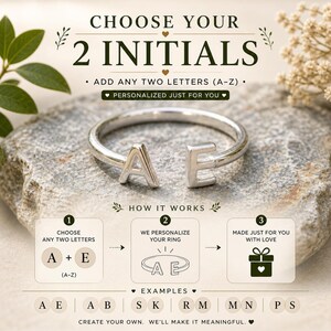 Op de afbeelding: Een zilverkleurige ring met de initialen "A" en "E" wordt getoond op een stenen oppervlak. De afbeelding bevat de tekst "CHOOSE YOUR 2 INITIALS" en "PERSONALIZED JUST FOR YOU". De ring is een gepersonaliseerd sieraad.