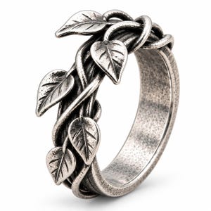May include: A silver-toned metal ring featuring a textured, oxidized finish. The band is designed to resemble intertwined vines with several small, detailed leaves extending from the surface, creating a dimensional, organic appearance.