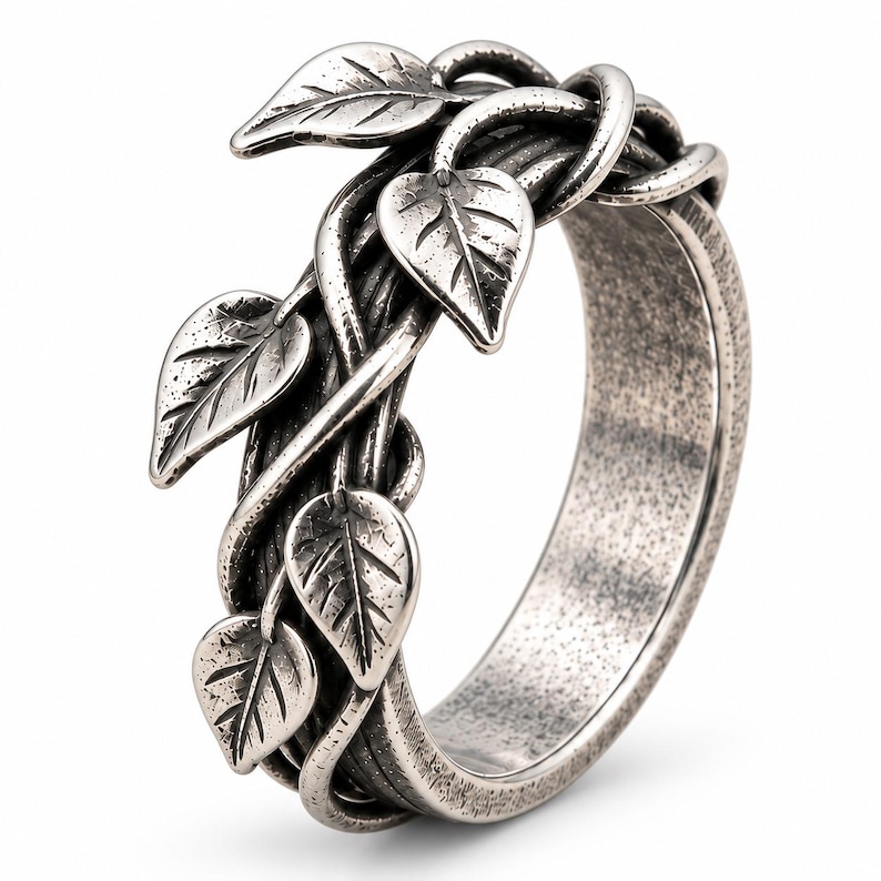 May include: A silver-toned metal ring featuring a textured, oxidized finish. The band is designed to resemble intertwined vines with several small, detailed leaves extending from the surface, creating a dimensional, organic appearance.