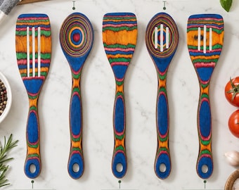 May include: A set of five wooden kitchen utensils featuring a vibrant, multi-colored striped pattern in blue, green, orange, and red. The set includes a slotted spatula, a spoon, a spatula, a slotted spoon, and a slotted turner, each with a hole in the handle.