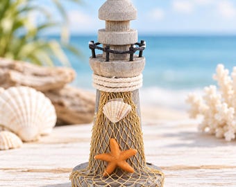 May include: A decorative wooden lighthouse figurine featuring a weathered gray finish, wrapped in a tan fishing net. The structure is adorned with a white rope accent, a small seashell, and an orange starfish attached to the front surface.