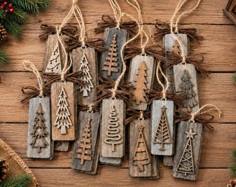 May include: A collection of rectangular wooden ornaments, each featuring a unique cutout or relief design of a Christmas tree. Each piece is finished with a brown twine loop and a small tied bow, showcasing various wood tones and textures.