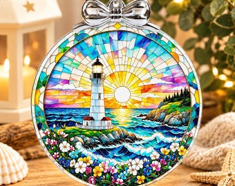 May include: A round, stained-glass style ornament featuring a lighthouse on a rocky cliff overlooking a blue ocean at sunset. The scene includes a bright yellow sun, colorful clouds, and a foreground filled with white, yellow, and blue flowers.