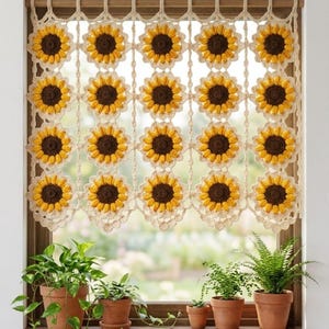 Può includere: Una tenda da finestra all'uncinetto con un motivo ripetuto di girasoli con centri marrone scuro e petali giallo brillante, collegati da anelli di filo color crema. La tenda è appesa a un bastone di legno all'interno del telaio della finestra.