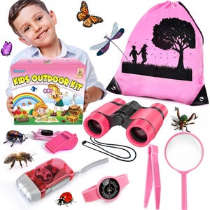 Op de afbeelding: Een roze Kids Outdoor Kit met een verrekijker, een zaklamp, een kompas horloge, een vergrootglas en andere accessoires. De kit bevat een roze trekkoordtas met een silhouet van kinderen en een boom. De doos leest "KIDS OUTDOOR KIT".
