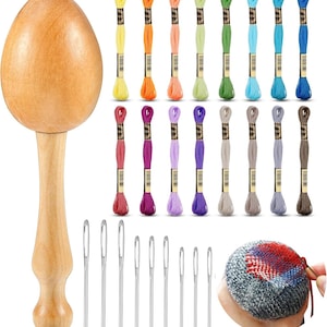 May include: A wooden egg-shaped darning mushroom with a handle, a collection of embroidery floss in various colors, and a set of sewing needles. The image also shows a small, round, knitted item with colorful patches.