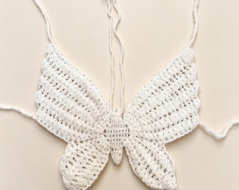 Top cropped de crochê artesanal com borboletas, modelo frente única com cordão ajustável nas costas, peça boho para praia e festivais de verão.