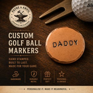 May include: A copper golf ball marker with the word "DADDY" stamped on it. The marker has a hammered texture. The image also shows a golf ball, a divot repair tool, and text that reads "Custom Golf Ball Markers."