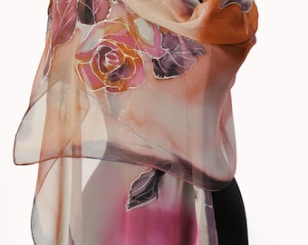 May include: A sheer silk scarf with a floral design featuring roses and leaves in shades of pink, orange, and purple. The scarf is draped over a mannequin.