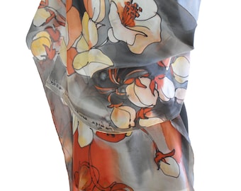 May include: A gray silk scarf with a floral print in shades of orange, white, and yellow. The flowers are stylized and abstract, with a painterly look.