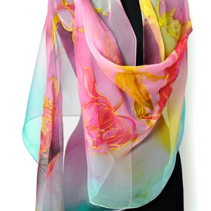 May include: A pink, yellow, and turquoise silk scarf with a floral design. The scarf is draped over a black mannequin.
