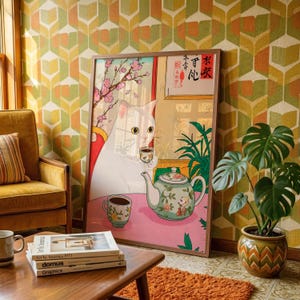 Peut inclure: Une affiche encadrée représentant un chat blanc buvant du thé, avec une théière et une tasse sur une surface rose. L'œuvre d'art a une esthétique japonaise, avec des fleurs de cerisier et du texte en arrière-plan. L'affiche est dans une pièce avec du papier peint rétro et une plante en pot.